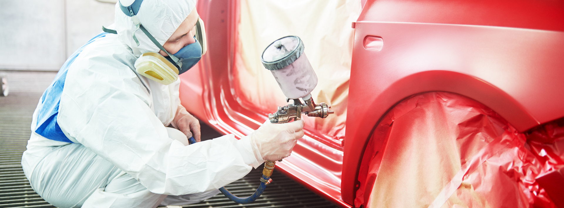 Image of a man painting a car.